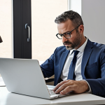 **Prompt:** A male professional consultant in his late 30s-early 40s, embodying a 'flow state.' He is seated at a clean, modern desk, deeply focused on his laptop, with a serene expression. His smartphone is faced down or clearly put away, indicating no distractions. The background is softly blurred but hints at a light-filled, organized home office or professional workspace. The overall mood is calm, productive, and balanced. High detail, realistic photography.